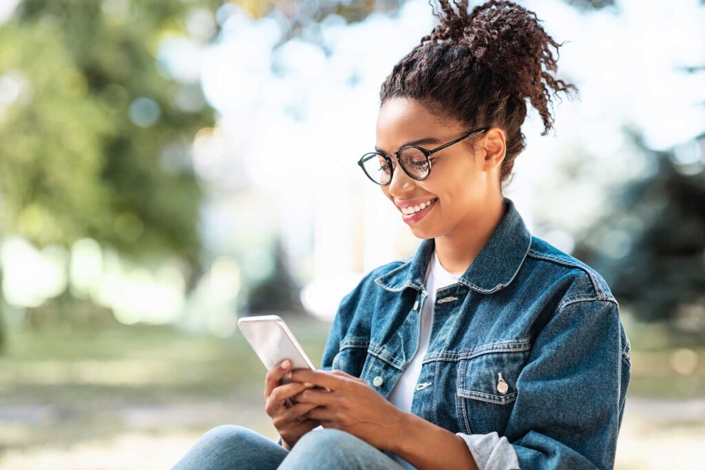 black-lady-with-smartphone-using-mobile-app-sittin-Z96AR67.jpg