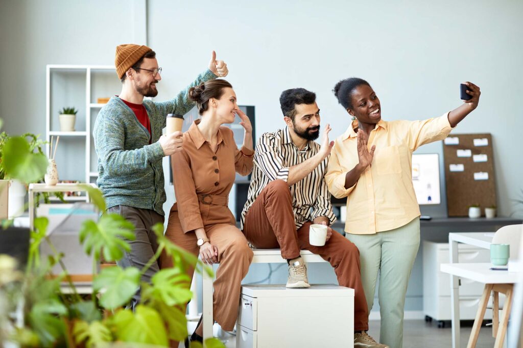 side-view-of-four-young-cheerful-employees-waving-3FU7YSP.jpg